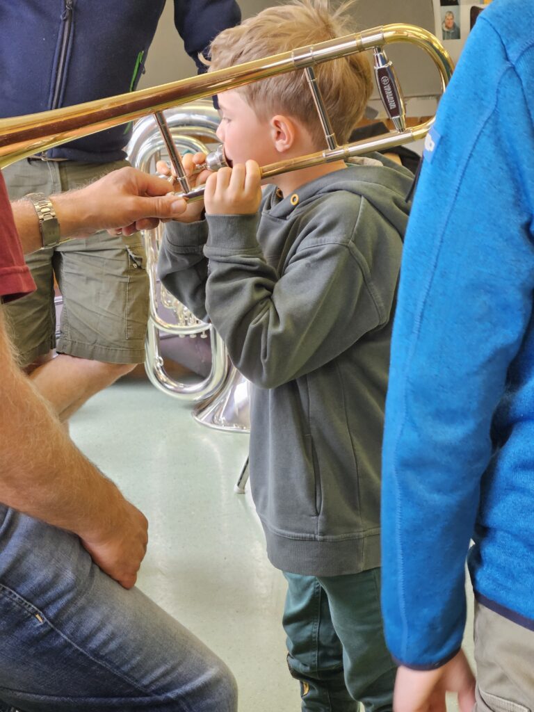 ein Junge bläst in eine Posaune